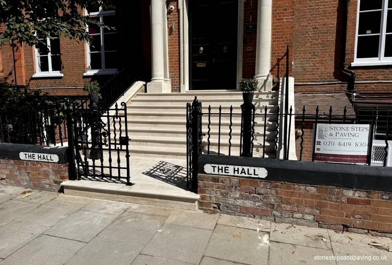 Red-brick Victorian school entrance with a stone portico above new Portland stone steps in Belsize Park