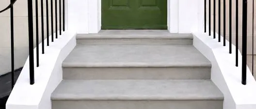 Completed Yorkstone entrance steps with bullnosed treads between white rendered walls and black railings, Penzance Place, Notting Hill W11